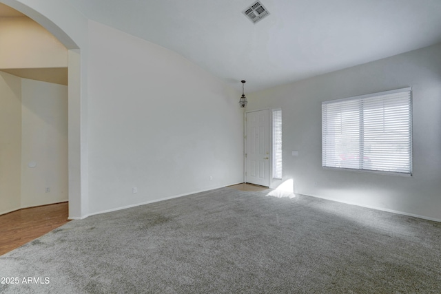 empty room featuring lofted ceiling and light colored carpet