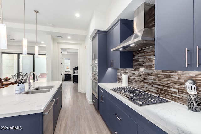 kitchen with blue cabinets, wall chimney exhaust hood, and sink