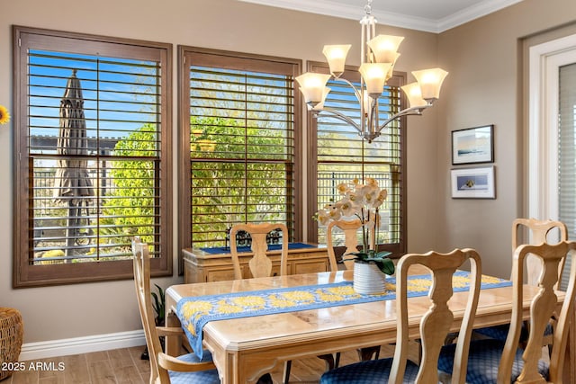 dining room featuring crown molding, wood finished floors, baseboards, and a chandelier