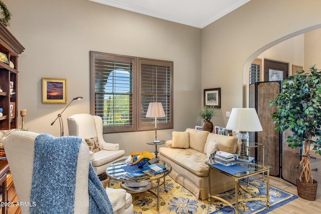 living room with arched walkways, crown molding, and wood finished floors