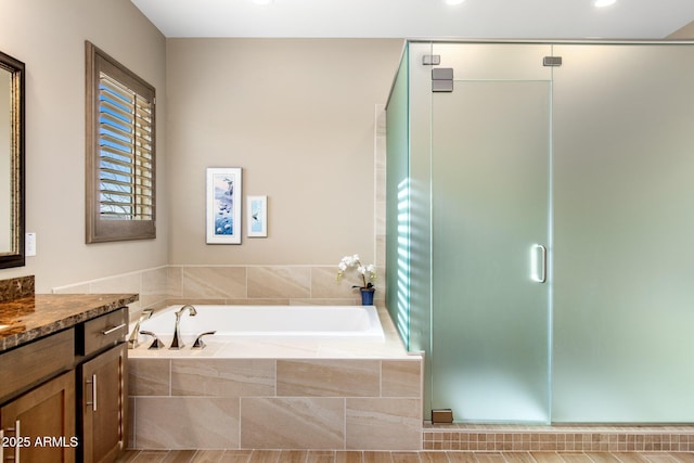 bathroom with a bath, a shower stall, and vanity