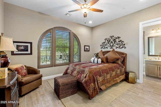 bedroom with a sink, visible vents, baseboards, and light wood-style floors