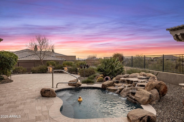 view of swimming pool with a patio area and fence