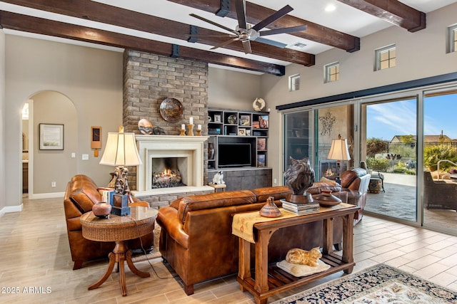 living area with wood finish floors, arched walkways, and ceiling fan