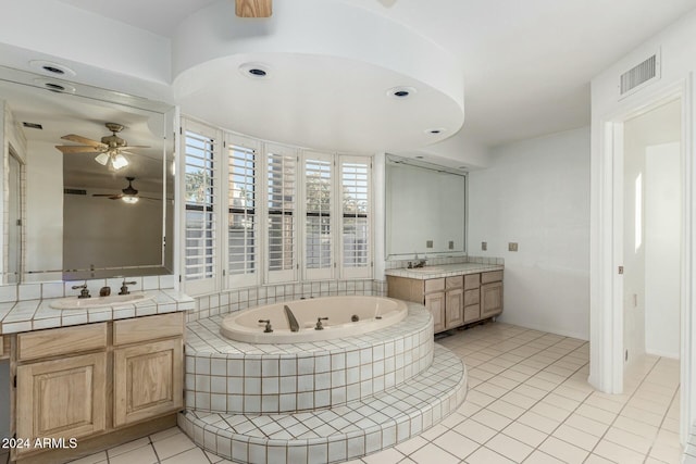 bathroom with vanity, a relaxing tiled tub, and tile patterned floors