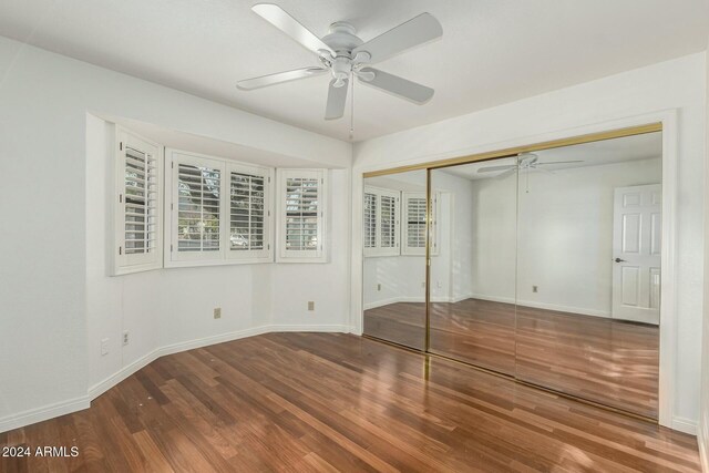 unfurnished bedroom with wood-type flooring, a closet, and ceiling fan