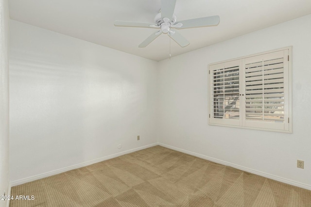 unfurnished room featuring light colored carpet and ceiling fan