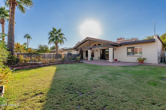 rear view of property with a lawn and a patio