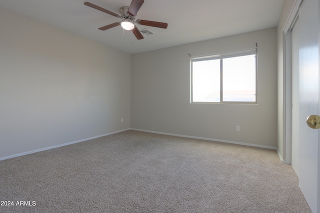 spare room with light colored carpet and ceiling fan