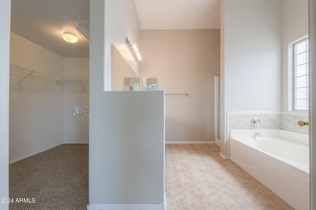 bathroom with a textured ceiling, tile patterned flooring, and a washtub