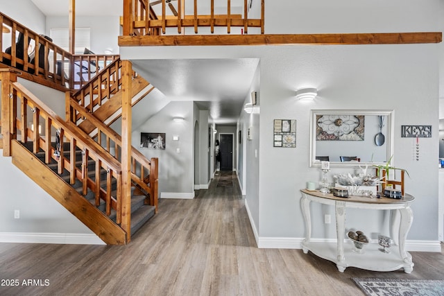 interior space with baseboards, stairway, and wood finished floors