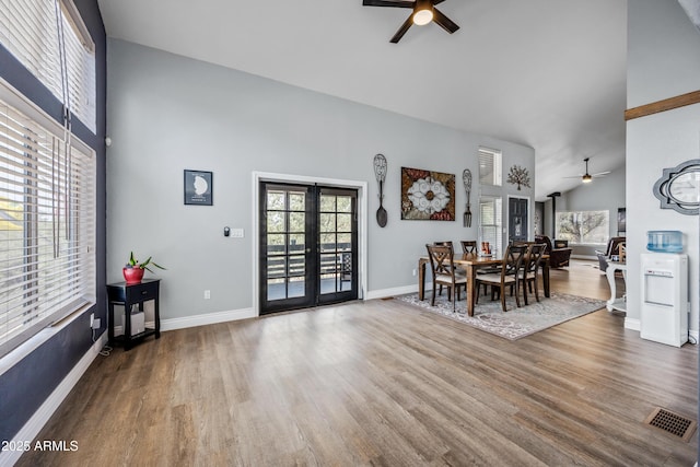 dining area featuring french doors, ceiling fan, high vaulted ceiling, and wood finished floors