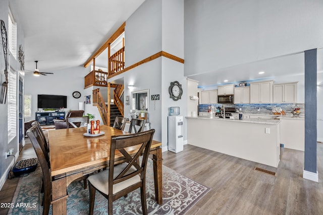 dining room with ceiling fan, stairway, wood finished floors, and baseboards