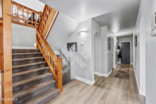 staircase featuring baseboards and wood finished floors