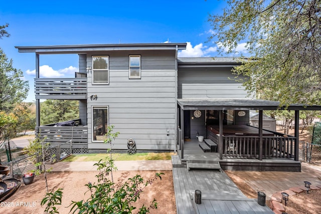 rear view of property with a deck and a balcony