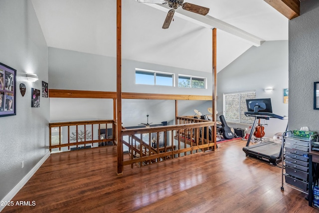 living room with a ceiling fan, wood finished floors, a textured wall, baseboards, and beam ceiling