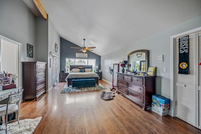 bedroom with high vaulted ceiling, multiple windows, wood finished floors, and a ceiling fan