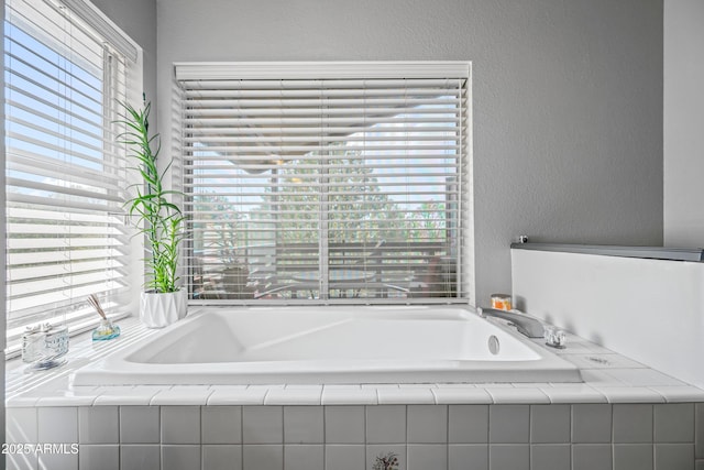 full bathroom with a textured wall and a garden tub