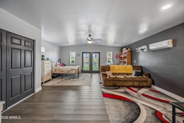 living area featuring ceiling fan, a wall mounted AC, wood finished floors, lofted ceiling, and baseboards