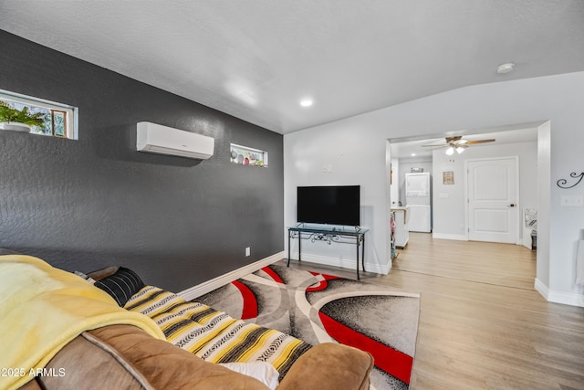 living area with a wall unit AC, a ceiling fan, recessed lighting, wood finished floors, and baseboards