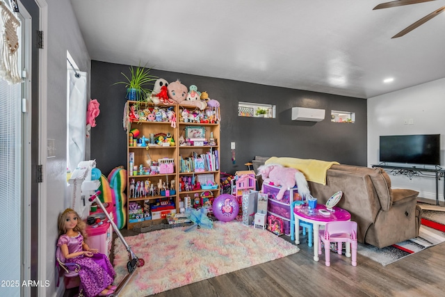 playroom featuring ceiling fan, recessed lighting, wood finished floors, and a wall mounted air conditioner