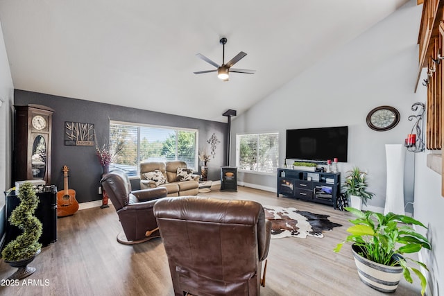 living area featuring wood finished floors, ceiling fan, baseboards, and high vaulted ceiling