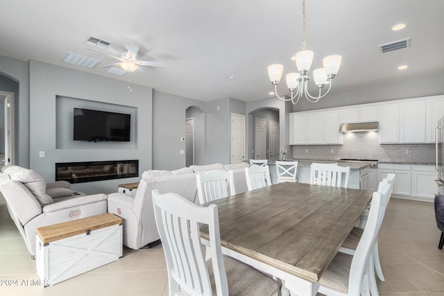 dining room featuring ceiling fan with notable chandelier and light tile patterned floors