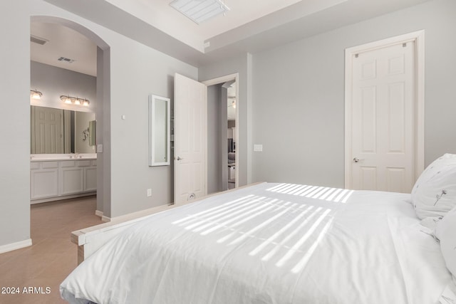 tiled bedroom with connected bathroom and a closet