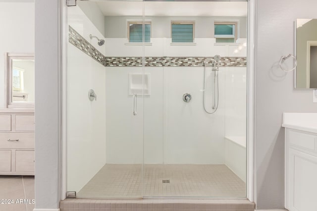 bathroom featuring tile patterned flooring, vanity, and an enclosed shower