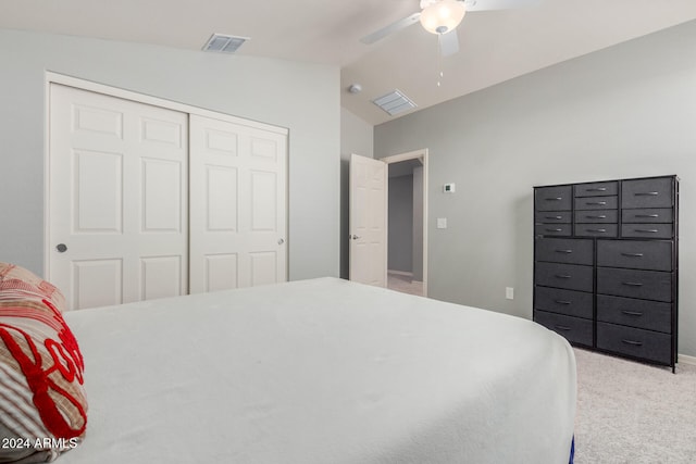 carpeted bedroom with ceiling fan, a closet, and lofted ceiling