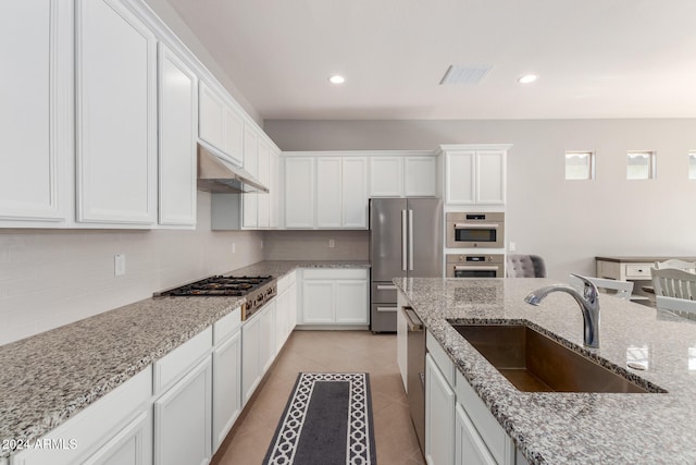 kitchen featuring light stone countertops, white cabinets, sink, and stainless steel appliances