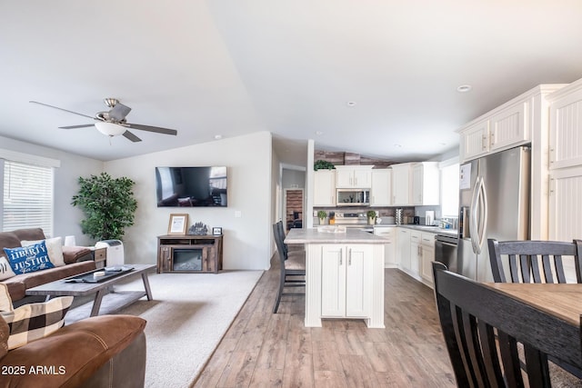 kitchen featuring light countertops, a wealth of natural light, open floor plan, and appliances with stainless steel finishes