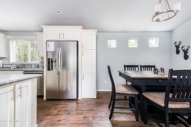 dining space featuring a notable chandelier, dark wood-type flooring, and baseboards