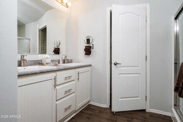 full bathroom with wood finished floors, a stall shower, and a sink