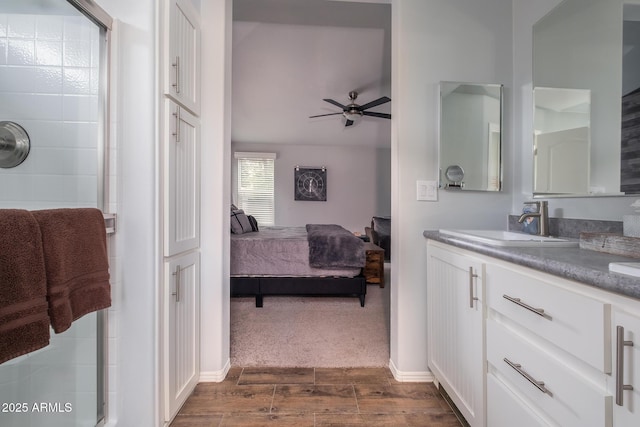 full bath featuring a shower stall, wood finish floors, vanity, ensuite bath, and a ceiling fan