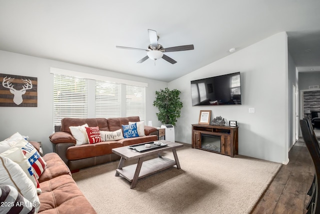 living room featuring a fireplace, wood finished floors, ceiling fan, and vaulted ceiling