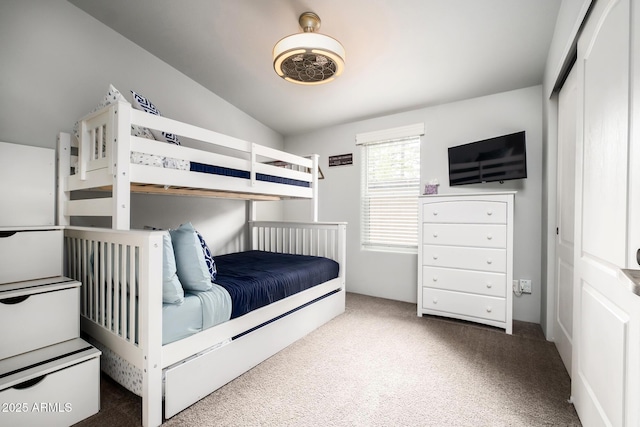 carpeted bedroom featuring a closet and lofted ceiling