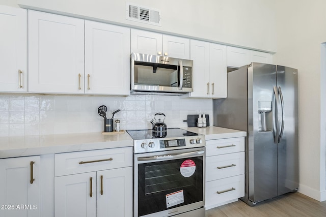 1021 S Almar Cir, Mesa, AZ 85204 - kitchen featuring stainless steel appliances, white cabinetry, and tasteful backsplash