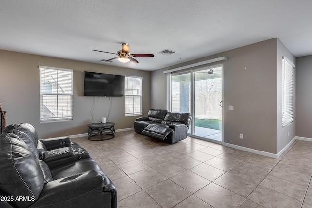 living room with visible vents, a healthy amount of sunlight, baseboards, and a ceiling fan