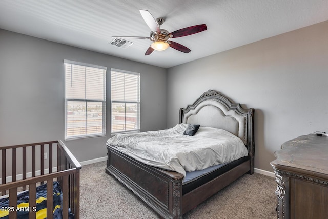 carpeted bedroom with visible vents, ceiling fan, and baseboards