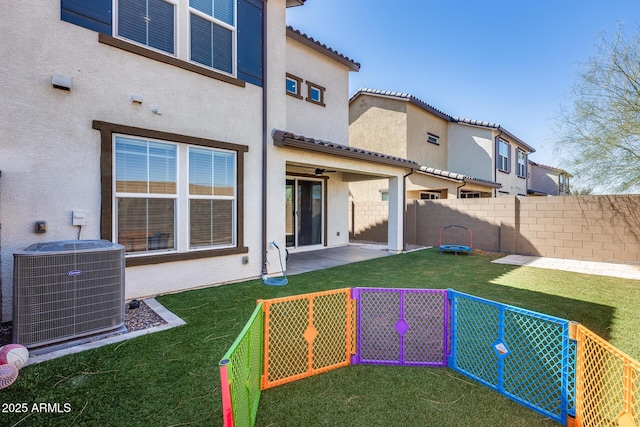 back of property featuring stucco siding, central AC unit, and fence