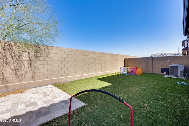 view of yard featuring a fenced backyard and central AC