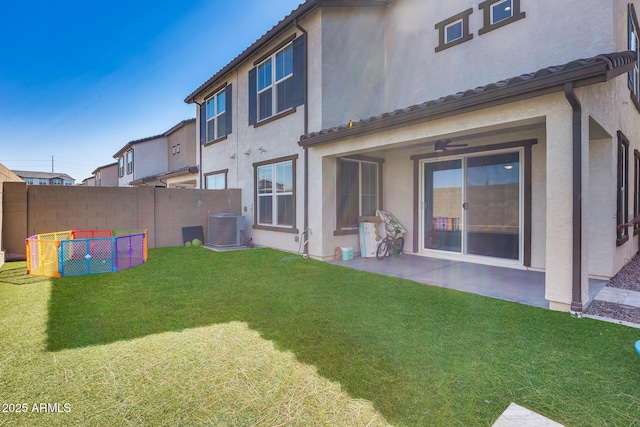 back of property featuring a patio, fence, a yard, central AC, and stucco siding