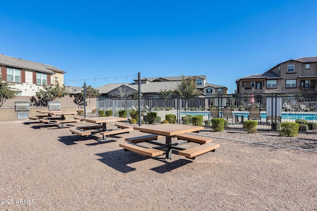 view of home's community with a pool, a residential view, a patio, and fence