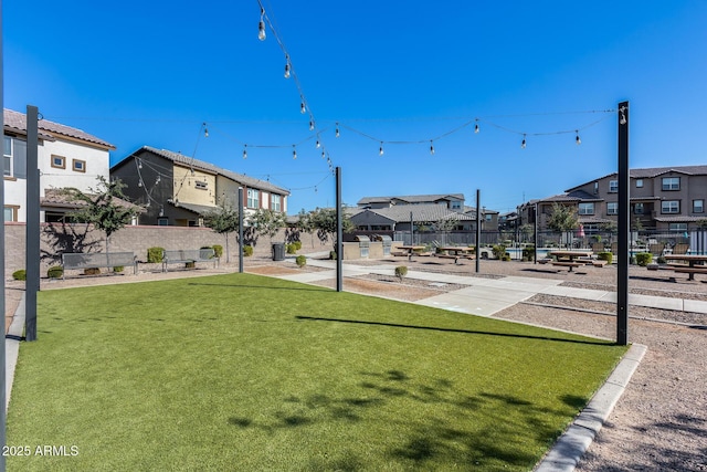 view of home's community featuring a yard, fence, and a residential view