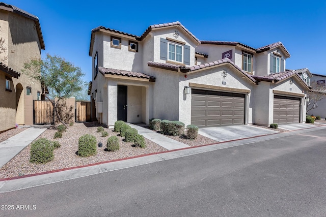 mediterranean / spanish-style house featuring fence, an attached garage, stucco siding, concrete driveway, and a tile roof