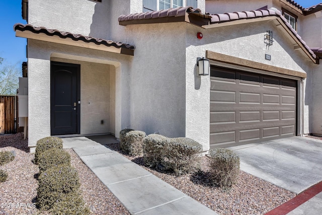 view of front facade featuring stucco siding, concrete driveway, and a tile roof