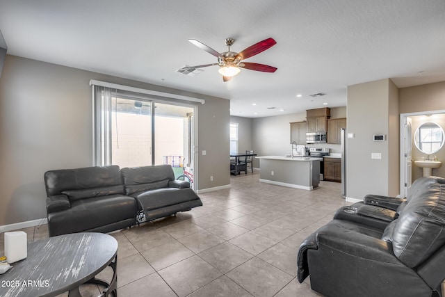 living room with light tile patterned floors, a ceiling fan, visible vents, baseboards, and recessed lighting