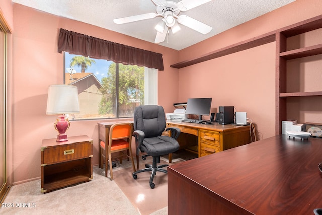 carpeted office featuring a textured ceiling and ceiling fan