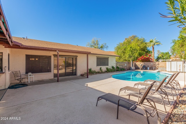 view of swimming pool with a patio and a storage unit